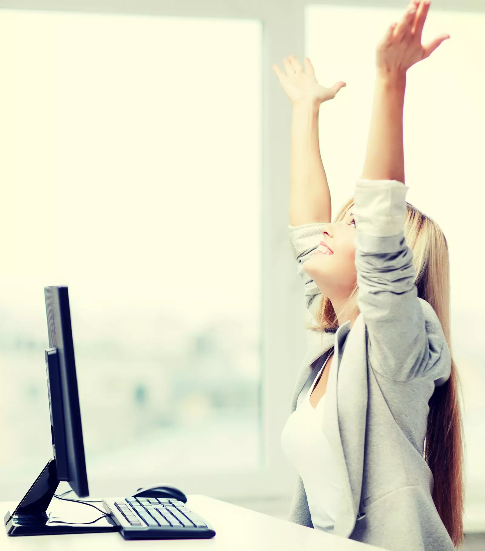 A female-employee raising her arms in the air out of joy.