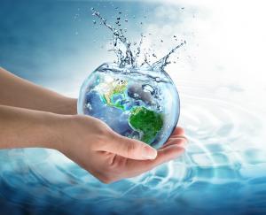 pair of hands holding glass bowl with earth's continents and water