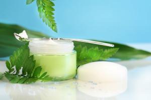 two jars of healthy body butter beside green leaves