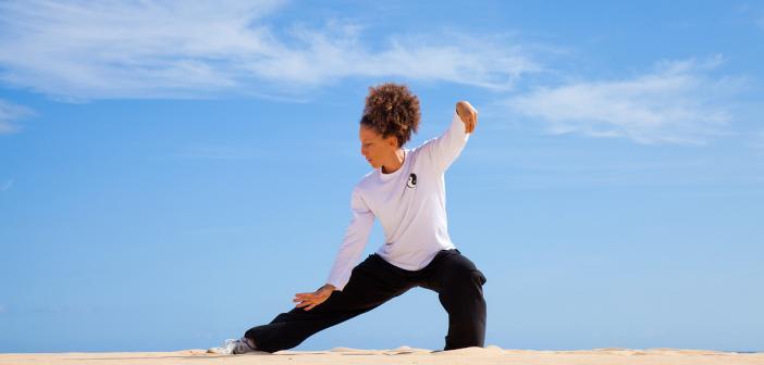 A woman practicing tai-chi in a natural environment.