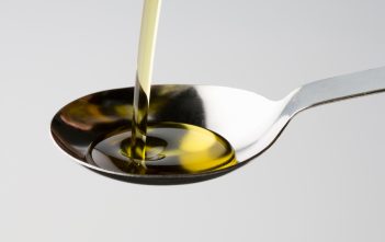castor oil pouring into a spoon