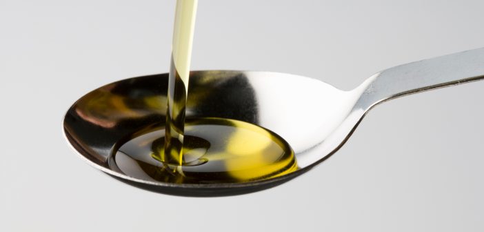 castor oil pouring into a spoon