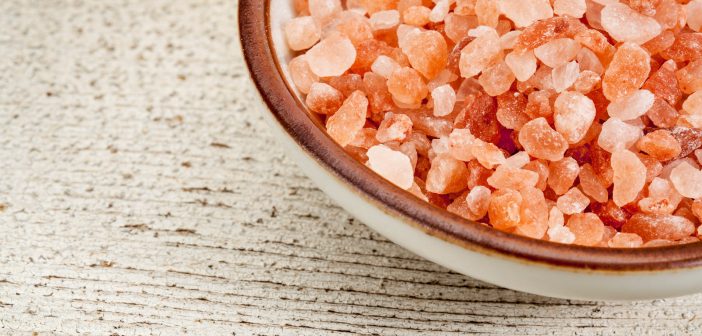 Himalayan salt crystals in a ceramic bowl on a board