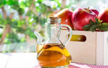 apple cider vinegar beside basket of apples