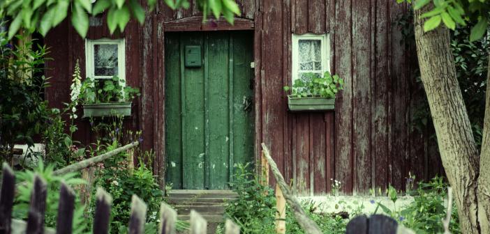 front door of homestead with plants and picket fence